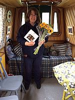 Sue with the flowers & chocolates standing in 10000 Reasons.