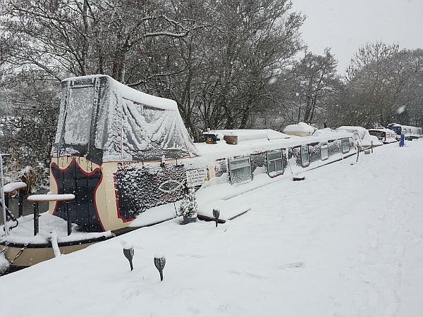A snow-covered Kairos moored up on the North Stratford Canal.