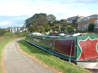"Days of Elijah" moored by a tarmac towpath.